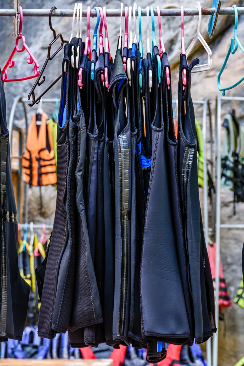 Spotless dive center gear room with BCDs, wetsuits, regulators and cylinders neatly racked